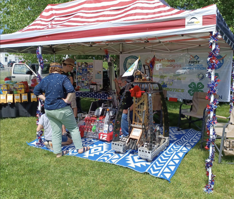 team booth at Bethlehem Jam Fest with two robots under decorated canopy