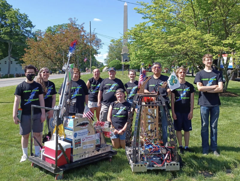 team group portrait with robot on town green ready for parade