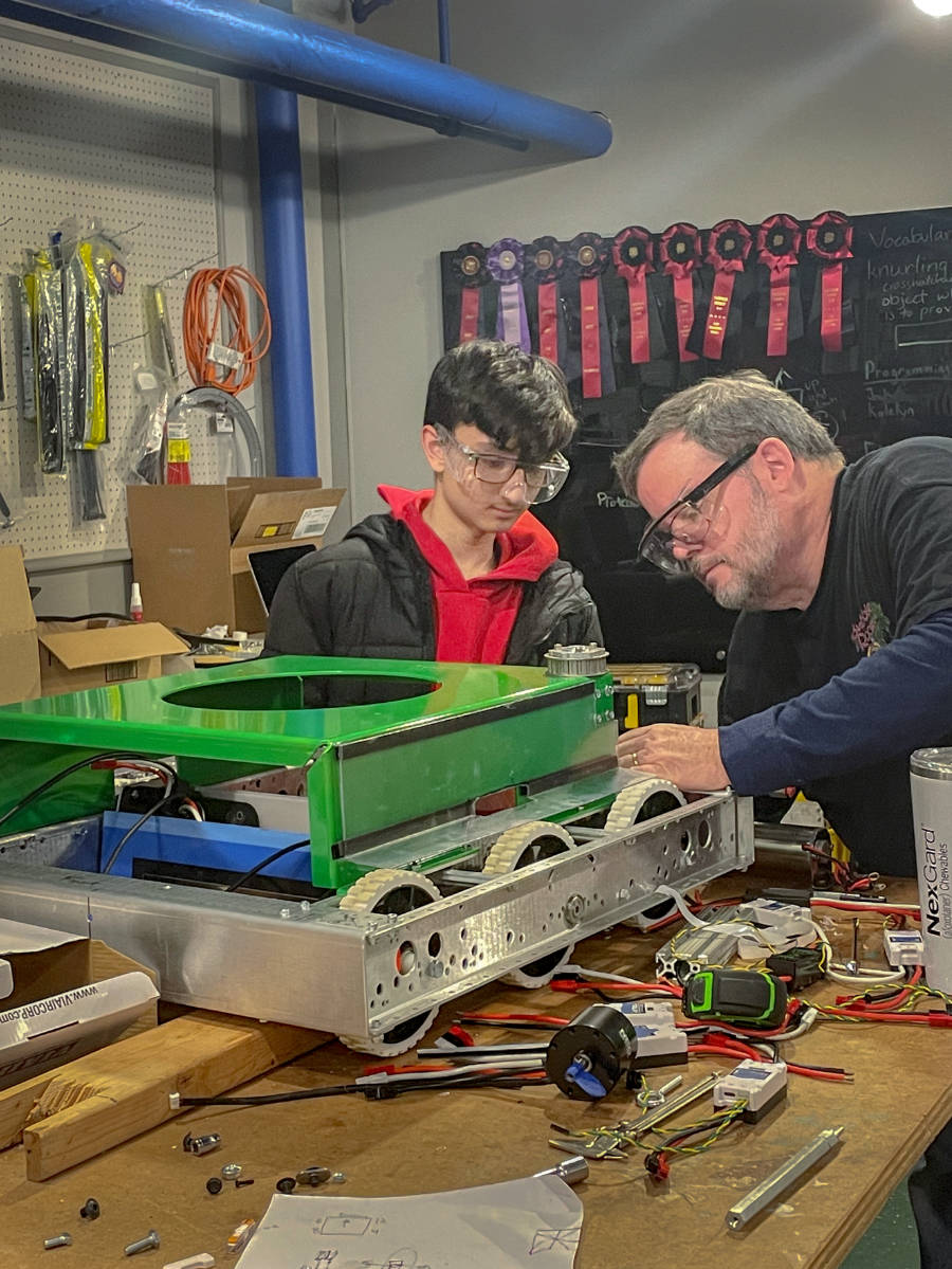 mentor and student installing platform on robot drivetrain