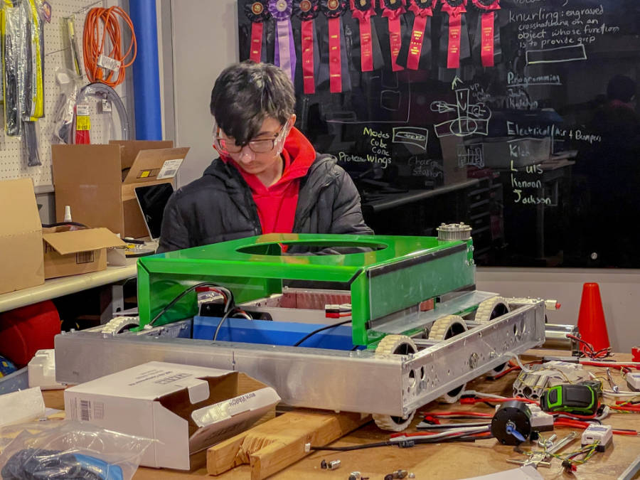 student working on robot base on shop bench