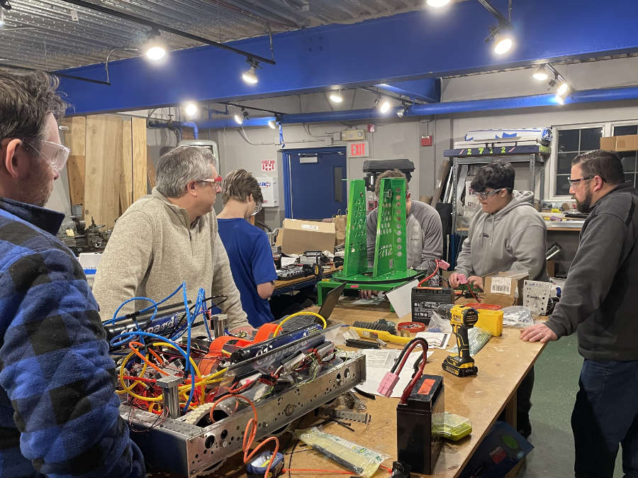 students and mentors working on turret at workbench