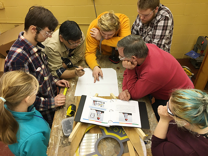 Students and Mentors around table planning robot design