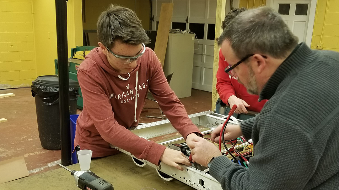 Mentor and student wiring a robot
