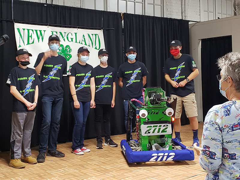 Six students on stage at Big-E with robot.