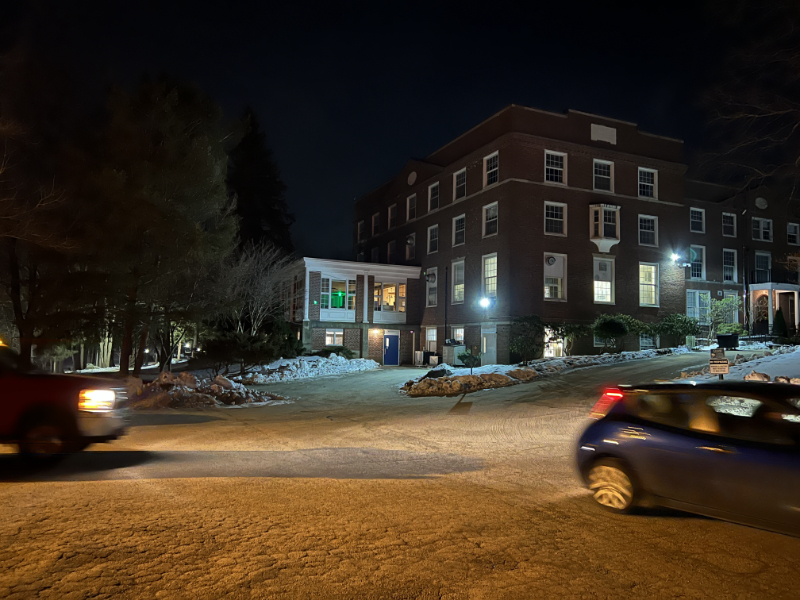 night scene of St Margaret Hall with light from windows on snowy drive