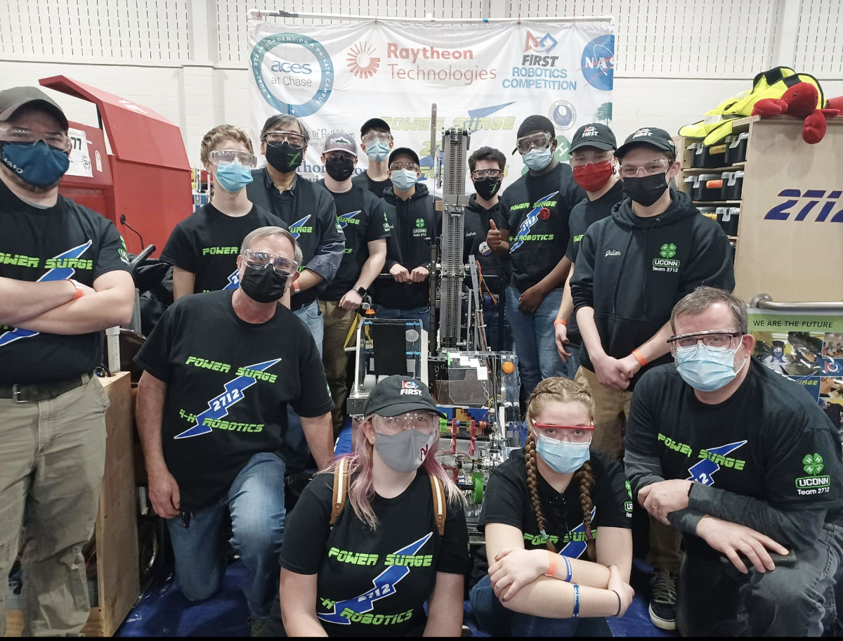 group team portrait with robot at a competition