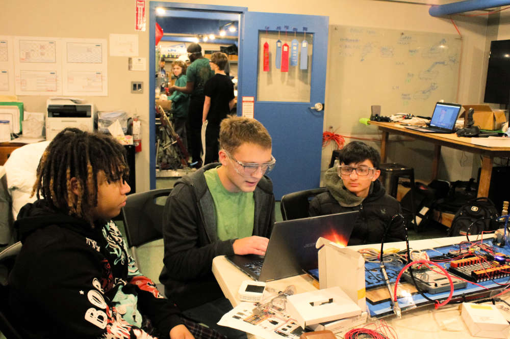 students working on programming or electronics at computer