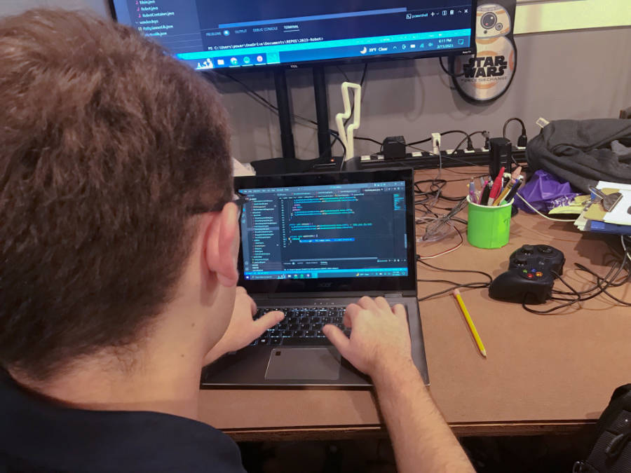student at computer working on programming code